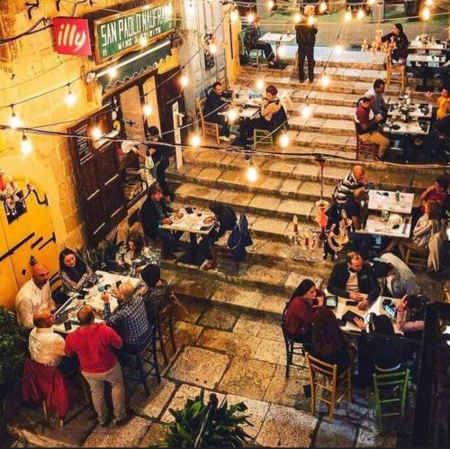 a group of people sitting at tables in a restaurant at Flat in Valletta in Valletta