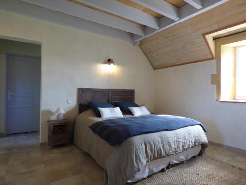 a bedroom with a large bed with blue and white pillows at BRITAVIT in Saint-Avit-Sénieur