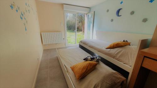 2 Betten in einem kleinen Zimmer mit Fenster in der Unterkunft Villa avec piscine aux pieds des collines de Marcel Pagnol in Allauch