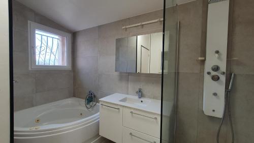 a bathroom with a tub and a sink and a shower at Villa avec piscine aux pieds des collines de Marcel Pagnol in Allauch