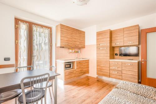 a kitchen with wooden cabinets and a table and chairs at CROSINA HOLIDAY - Residence Toli in Ledro