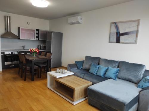 - un salon avec un canapé et une table dans l'établissement Klaipėdos 99 Apartamentai, à Panevėžys