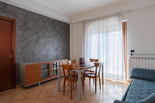 una cocina con mesa con sillas y ordenador portátil. en Hotel Azzurro, en LʼAquila