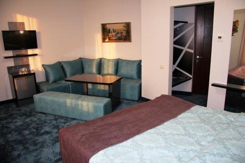 a hotel room with a bed and a couch and a table at Nice Hotel Yerevan in Yerevan