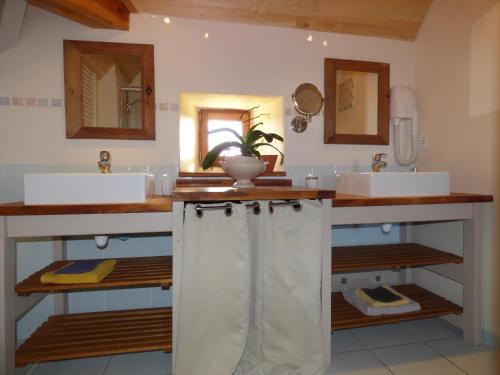 a bathroom with two sinks and two mirrors at BRITAVIT in Saint-Avit-Sénieur