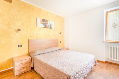 a small bedroom with a bed and a window at CROSINA HOLIDAY - Residence Toli in Ledro
