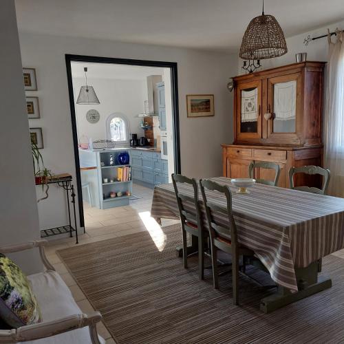 une salle à manger avec une table et des chaises et une cuisine dans l'établissement Fauvette17, à Saint-Palais-sur-Mer
