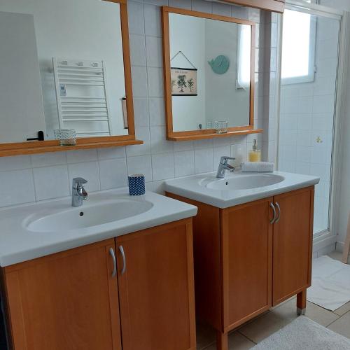 une salle de bain avec deux lavabos et un miroir dans l'établissement Fauvette17, à Saint-Palais-sur-Mer