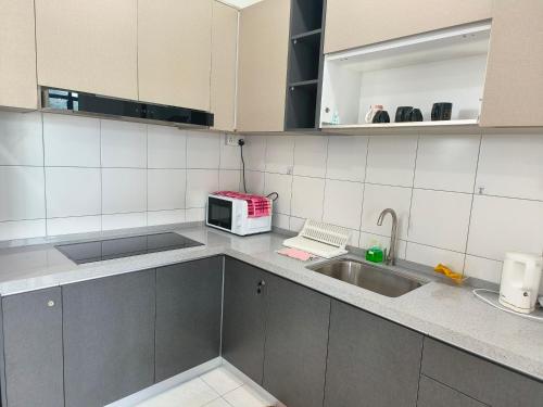 a kitchen with a sink and a microwave at The Sun 1 or 3BR Bayan Lepas 4 to 10 pax WL in Bayan Lepas