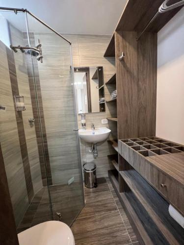 a bathroom with a glass shower and a sink at Hotel Boutique Business Center in Cali