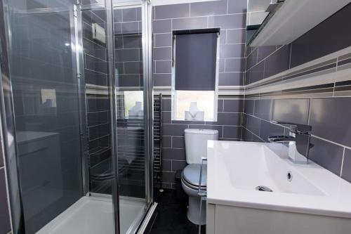 y baño con aseo, lavabo y ducha. en Spacious-Comfortable-Free Parking-Garden en Nottingham