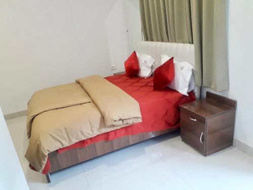 a bedroom with a bed with red and white pillows at PEACOCK HILL HOMESTAY in Bhopal