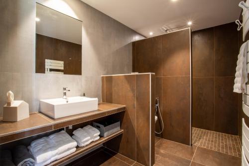 a bathroom with a sink and a shower at La Ferme du Lanchet in Lamoura