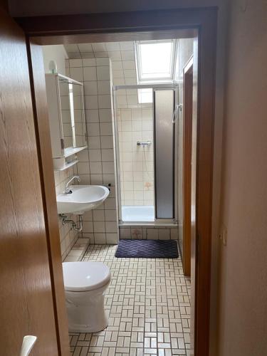 a bathroom with a shower and a toilet and a sink at Hotel Specht in Witten