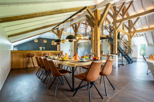 une salle à manger avec une grande table et des chaises en bois dans l'établissement La Ferme du Lanchet, à Lamoura