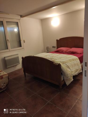 1 dormitorio con 1 cama grande con almohadas rojas en Maison avec deux chambres au calme, en Milly-la-Forêt