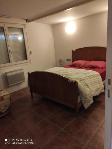 a bedroom with a large bed with red pillows at Maison avec deux chambres au calme in Milly-la-Forêt