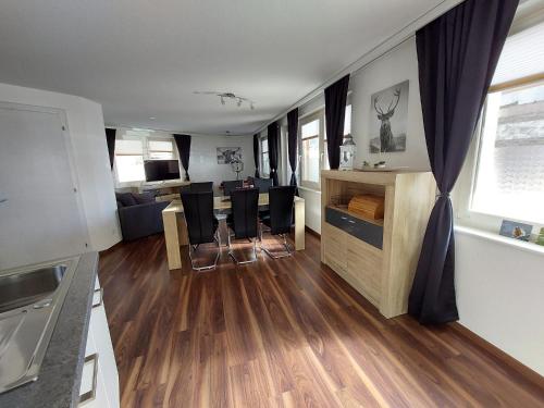 uma cozinha e sala de estar com mesa e cadeiras em Alpin Relax em Saas-Almagell