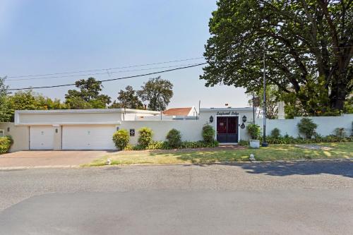 a white house with a garage at Leighwood Lodge in Johannesburg