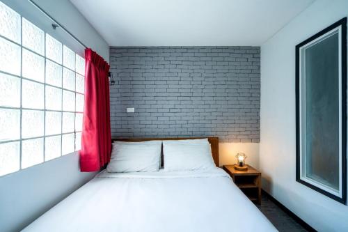 a bedroom with a bed with a red window at GO INN Sukhumvit 20 Bts Asoke-Phrom Phong in Bangkok