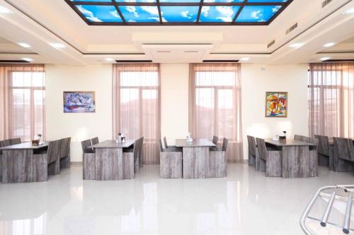 a large room with tables and chairs and a skylight at Nice Hotel Yerevan in Yerevan