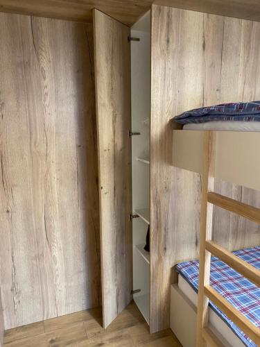 a room with two bunk beds and wooden walls at Drevenica Skye Terchová in Terchová