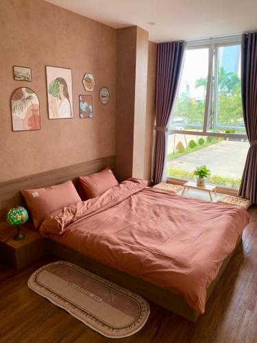 een groot bed in een slaapkamer met een raam bij LaLa Homestay in Hue