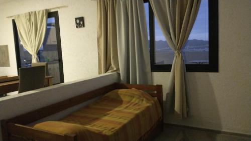 1 dormitorio con 1 cama frente a una ventana en La Roca en Villa Carlos Paz