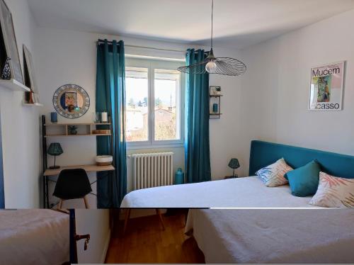 a bedroom with two beds and a window with blue curtains at Villa METICA - Aussillon/Mazamet in Aussillon