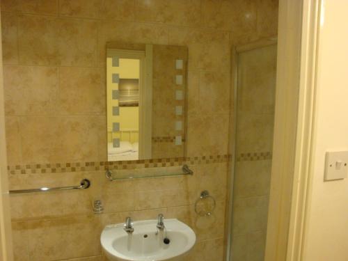 uma casa de banho com um lavatório e um espelho em Spencer Court em Ramsgate