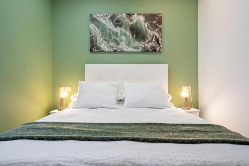 a bedroom with a large white bed with two lamps at Encantador apartamento en El Delta del Ebro-Apartaments Iaio Kiko in El Lligallo del Gànguil