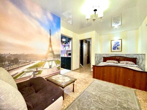 um quarto com uma cama e um quadro da Torre Eiffel em 1-кімн Французький шик у центрі Полтави ,Корпусний парк em Poltava