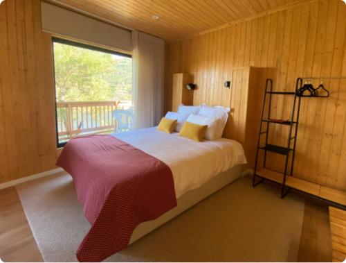 um quarto com uma cama grande e uma janela em Quinta Da Porta Caseira em Resende