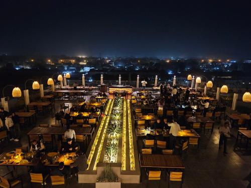 a restaurant with people sitting at tables at night at Tahir Guest Palace in Kano