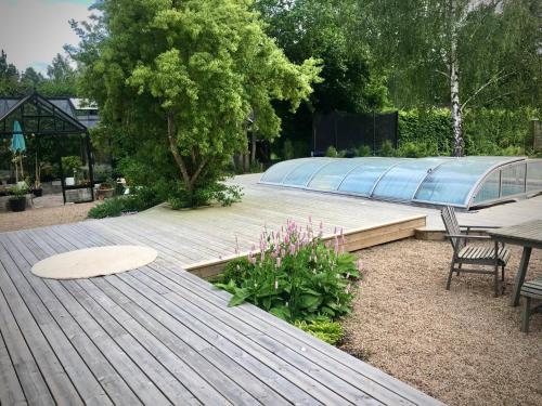 a wooden deck with a table and chairs in a garden at Charming little country house in central Älmhult in Älmhult