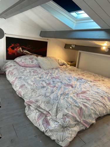 a bedroom with a large bed with a floral bedspread at 746 Aphrodite naturiste in Leucate