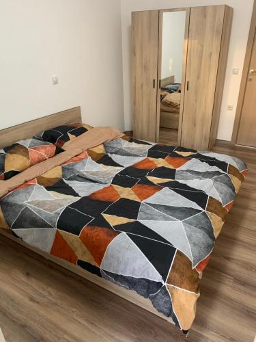 コチャニにあるApartment Trifunoviのベッドルームにカラフルな掛け布団付きのベッド1台