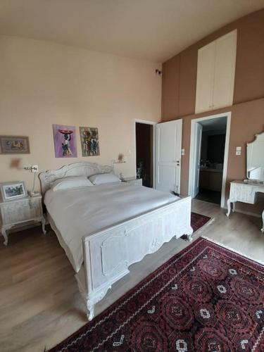 1 dormitorio con 1 cama blanca grande y 1 alfombra en Sea View House Voula en Atenas