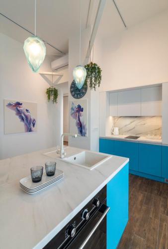 a kitchen with a sink and blue cabinets at Stylish 1 bedroom studio near Most City in Dnipro