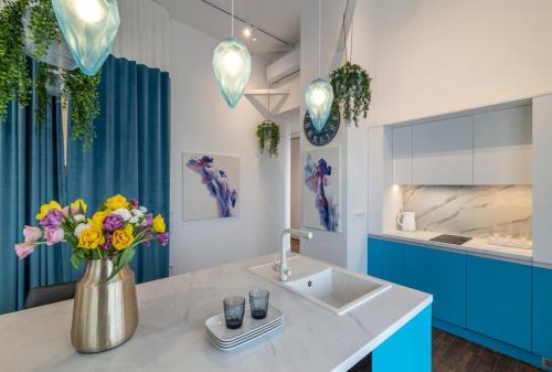 a bathroom with a sink and a vase of flowers at Stylish 1 bedroom studio near Most City in Dnipro