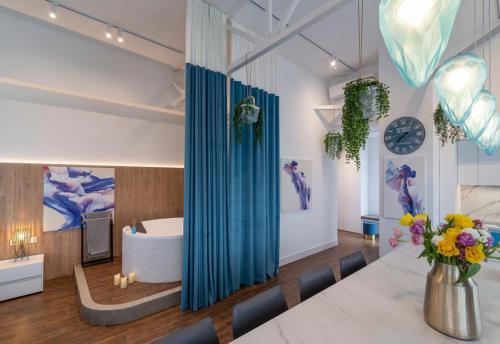 Cette chambre dispose d'une baignoire et d'une table avec des fleurs. dans l'établissement Stylish 1 bedroom studio near Most City, à Dnipro