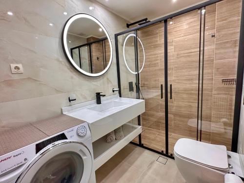 uma casa de banho com uma máquina de lavar roupa e um lavatório em Artdeco Luxury Suites em Korakiaí