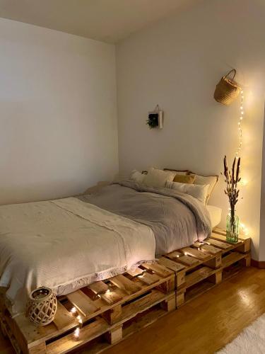 1 dormitorio con 1 cama con palé de madera en Le Plessis-Robinson - centre-ville, en Le Plessis-Robinson