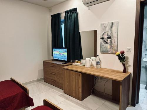 een kamer met een bureau, een computer en een raam bij Seaside Accomodation in Marsaskala