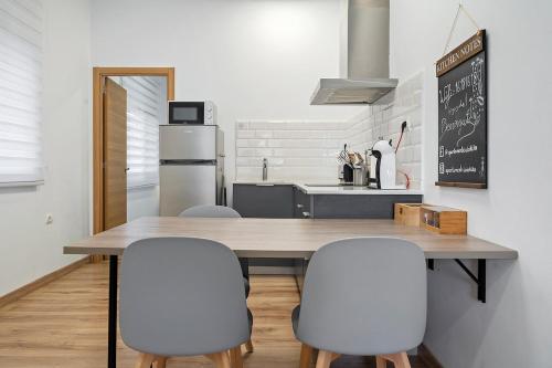 a kitchen with a wooden table and four chairs at Encantador apartamento en El Delta del Ebro-Apartaments Iaio Kiko in El Lligallo del Gànguil