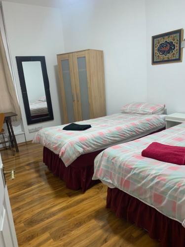 a bedroom with two beds and a mirror at The Dharma Lodge in Enfield