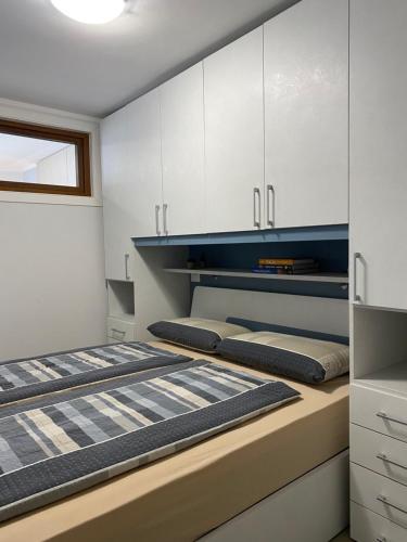two beds in a room with white cabinets at Casa Carla Typ 3 in Crone