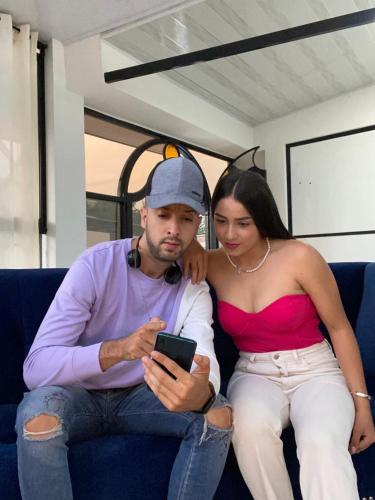 a man and a woman sitting on a couch looking at a cell phone at Heinz B. in Santa Ana de los Caballeros