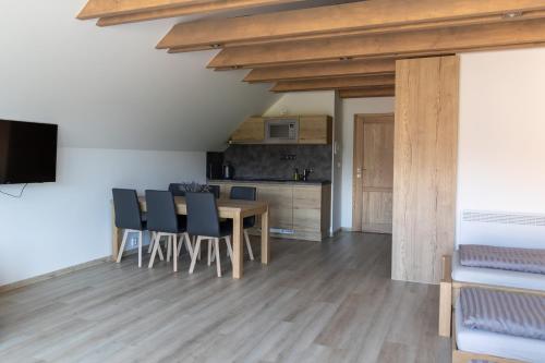 a kitchen and dining room with a table and chairs at Penzion Honzy in Bavory