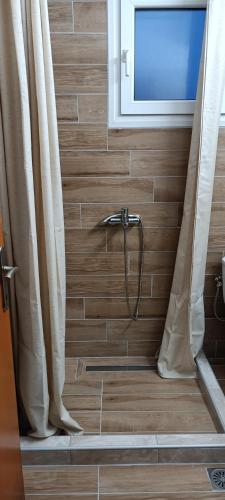 a bathroom with a shower with a window at Irini Apartments in Keramoti